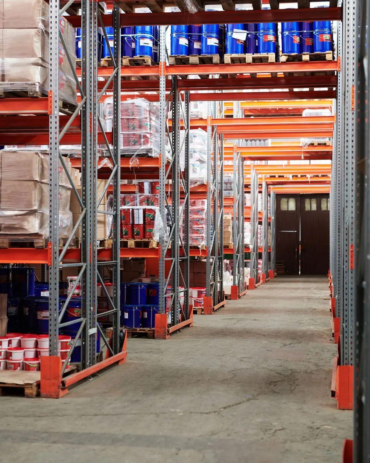 Rows of stocked warehouse racking, representing the physical inventory purchase orders and invoices are tracked against